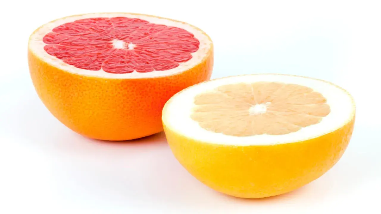Zwei Hälften von Grapefruits, eine rote und eine gelbe, zeigen, wie man eine Grapefruit schneidet.