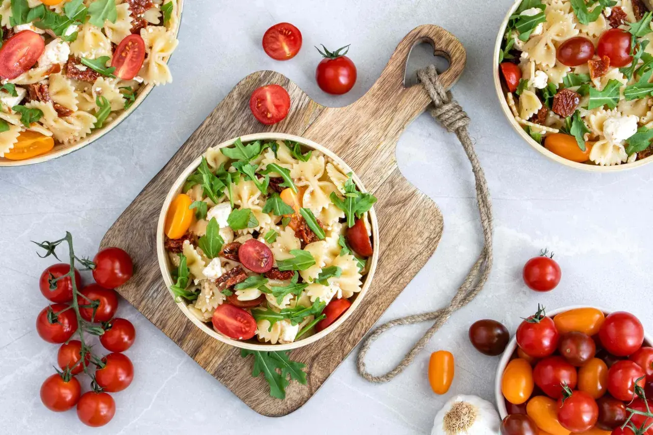 Ein köstlicher mediterraner Salat mit Farfalle, getrockneten Tomaten, frischen Kirschtomaten, Rucola und Feta.