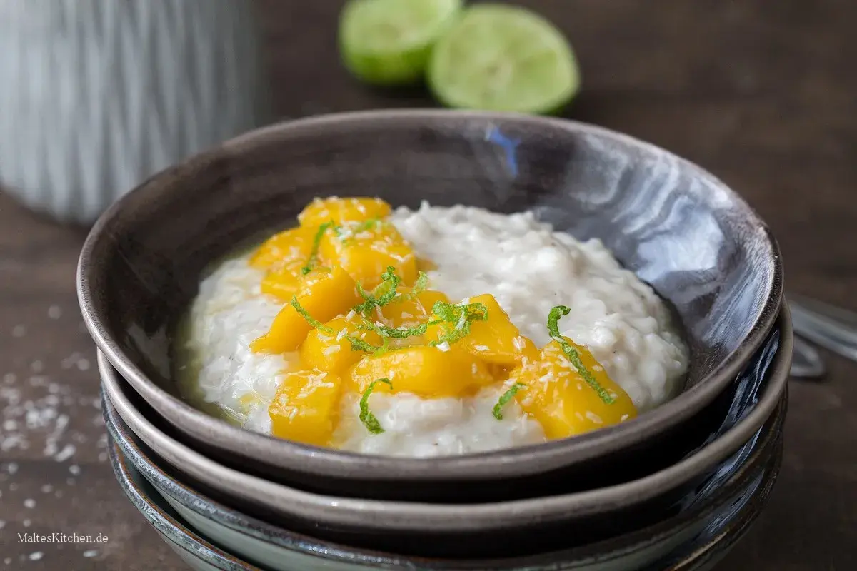 Cremiger Milchreis mit süßen Mangostücken und Kokosraspeln, eine köstliche Variante von Mango Sticky Rice.