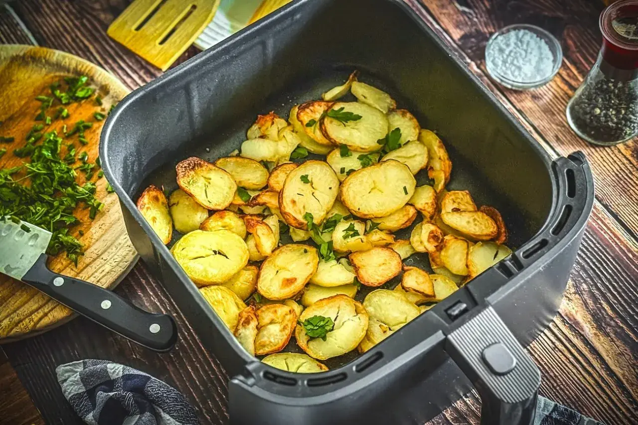 Goldbraune bratkartoffeln im Airfryer, garniert mit frischer Petersilie. Perfekt als Beilage oder Snack.