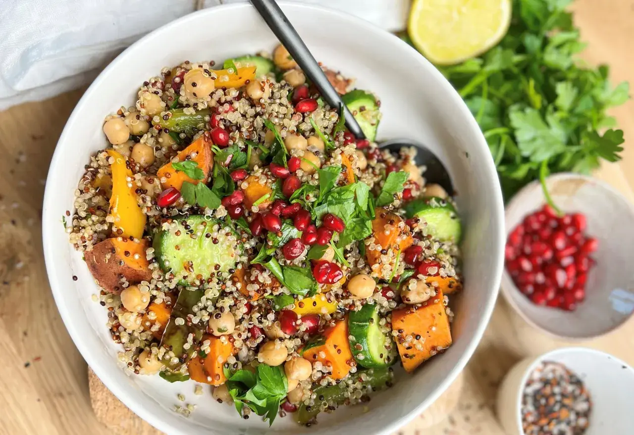 Bunter Quinoa-Salat mit Süßkartoffeln, Kichererbsen und Granatapfelkernen. Ein gesundes Gericht, das sich gut für Bowl-Rezepte eignet.