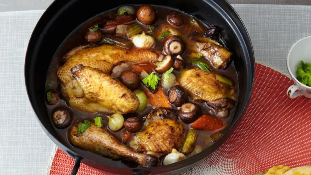 Coq au Riesling rezept original: Ein ganzer Brathähnchen-Mix mit Pilzen, Zwiebeln und Sellerie in dunkler Sauce.