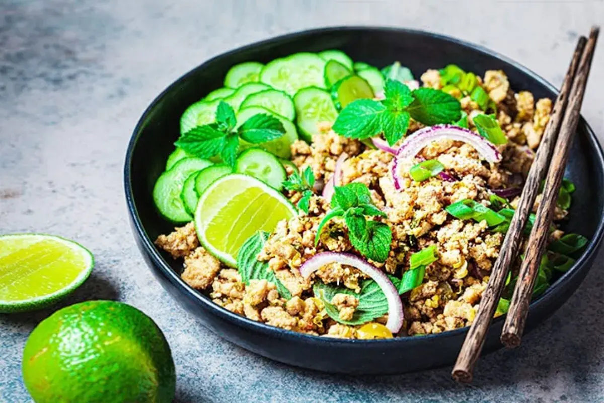 Würziges Laab Gai Rezept: Hackfleisch mit Gurkenscheiben, Minze, Limette und Zwiebelringen in einer Schüssel, bereit zum Genießen.