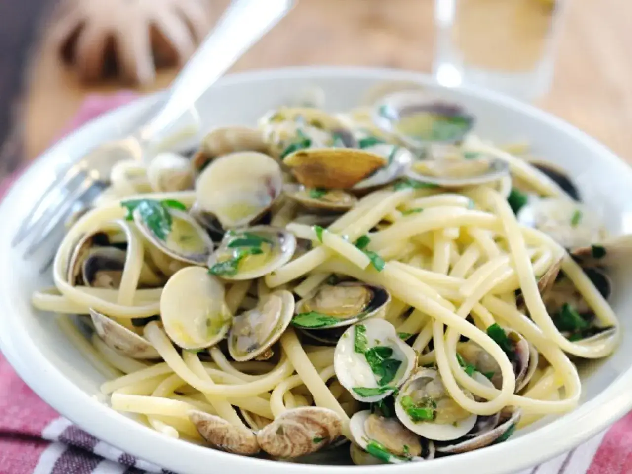 Ein Teller mit Spaghetti mit Muscheln, garniert mit frischer Petersilie.