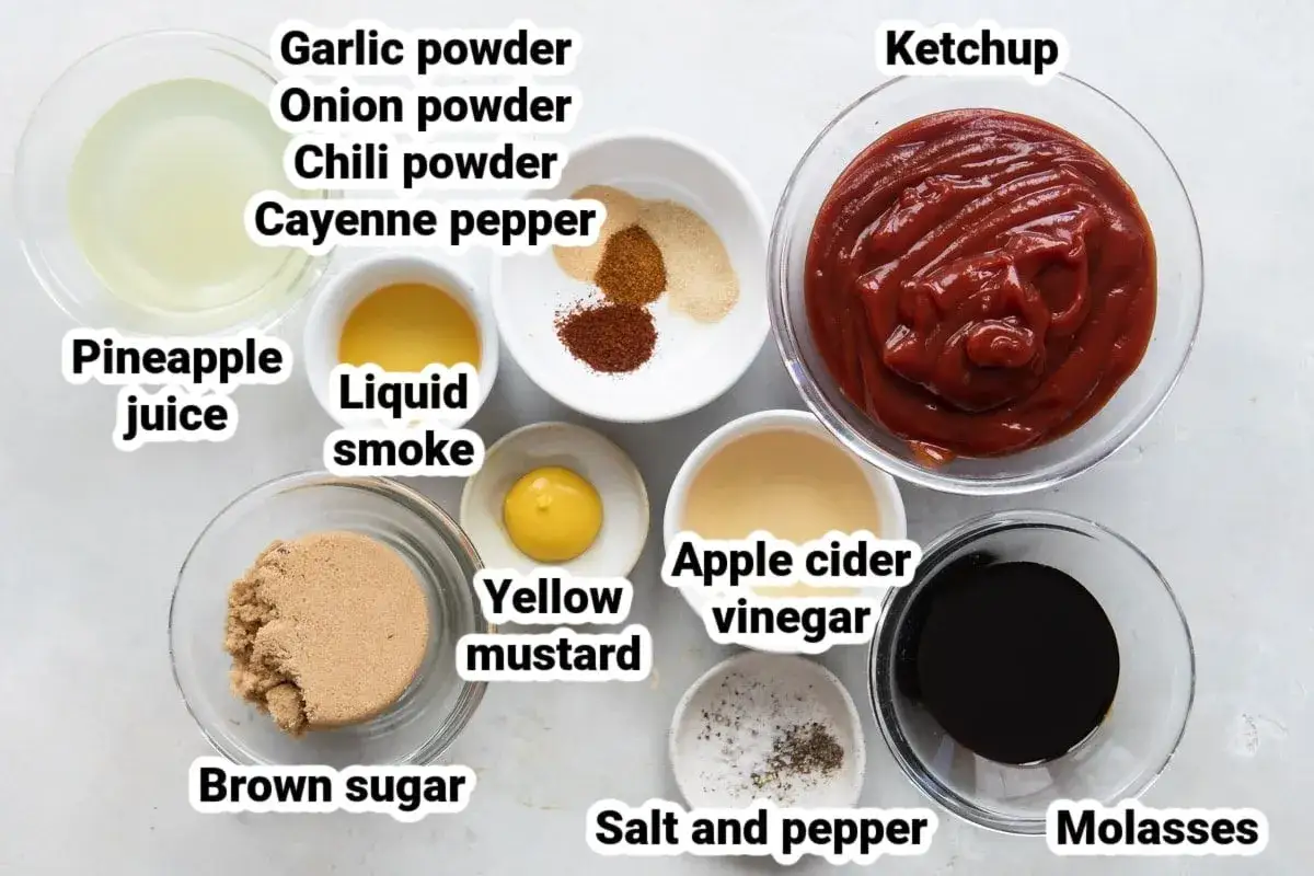 Zutaten f&uuml;r ein k&ouml;stliches BBQ Sauce Rezept: Ketchup, brauner Zucker, Ananassaft, Apfelessig, Rauchliquid, Senf, Knoblauch-, Zwiebel-, Chili- und Cayennepulver, Salz & Pfeffer.