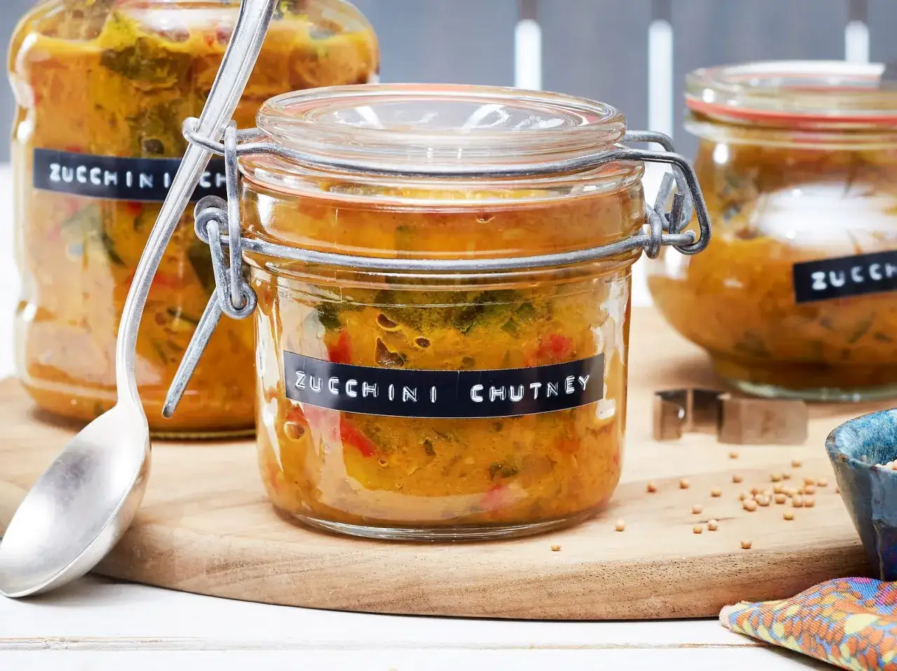 Zucchini-Chutney-Rezept in Gl&auml;sern, bereit zum Genie&szlig;en. Ein L&ouml;ffel liegt daneben, bereit zum Probieren.