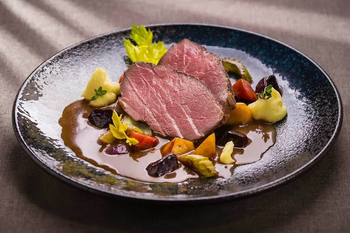 Zartes Kalbstafelspitz sous vide mit Kartoffelpüree und Wurzelgemüse in einer kräftigen Sauce.