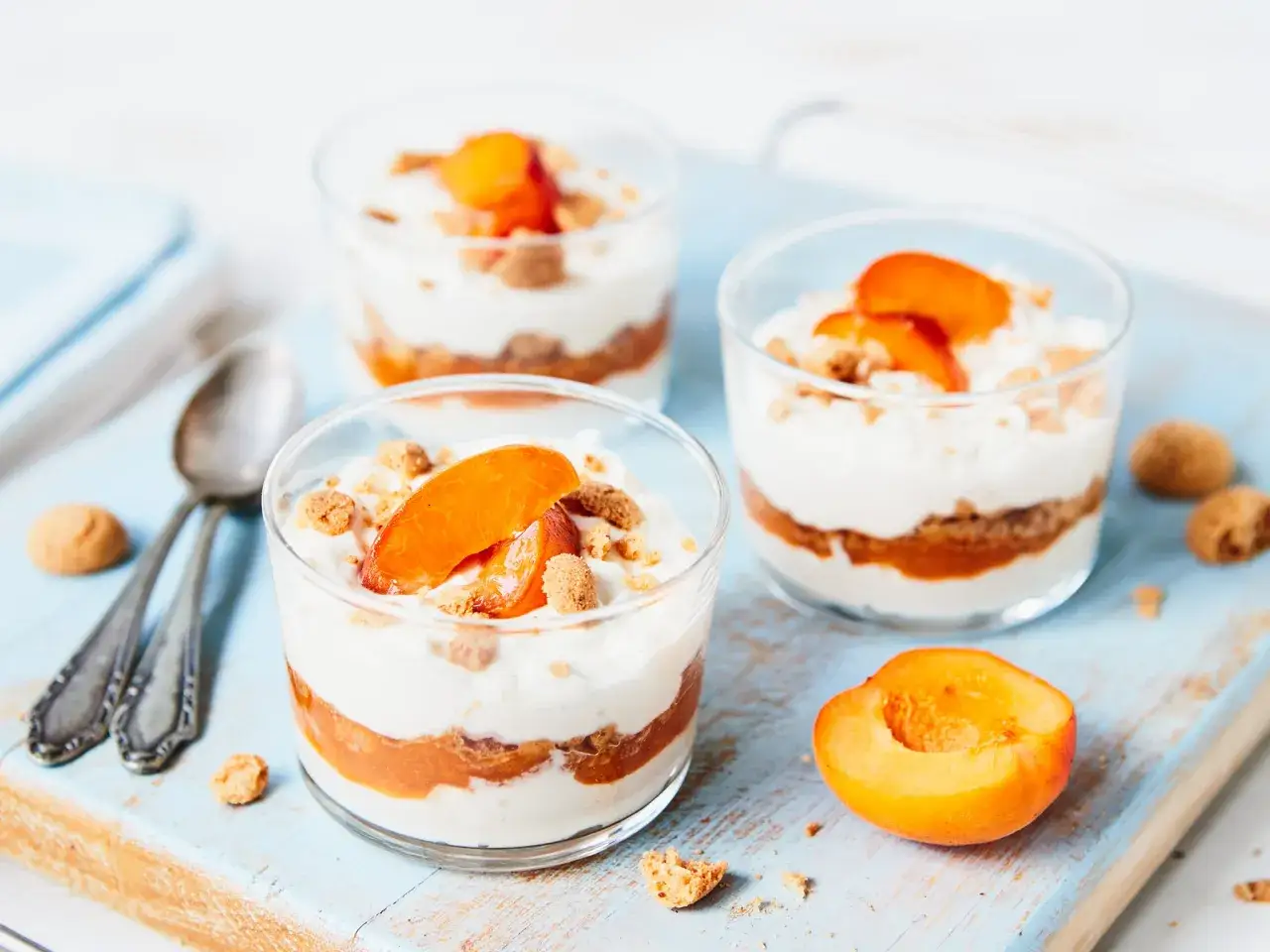 Cremiges Dessert mit Aprikosen und Mascarpone, geschichtet mit zerbröselten Keksen und garniert mit frischen Aprikosenspalten.