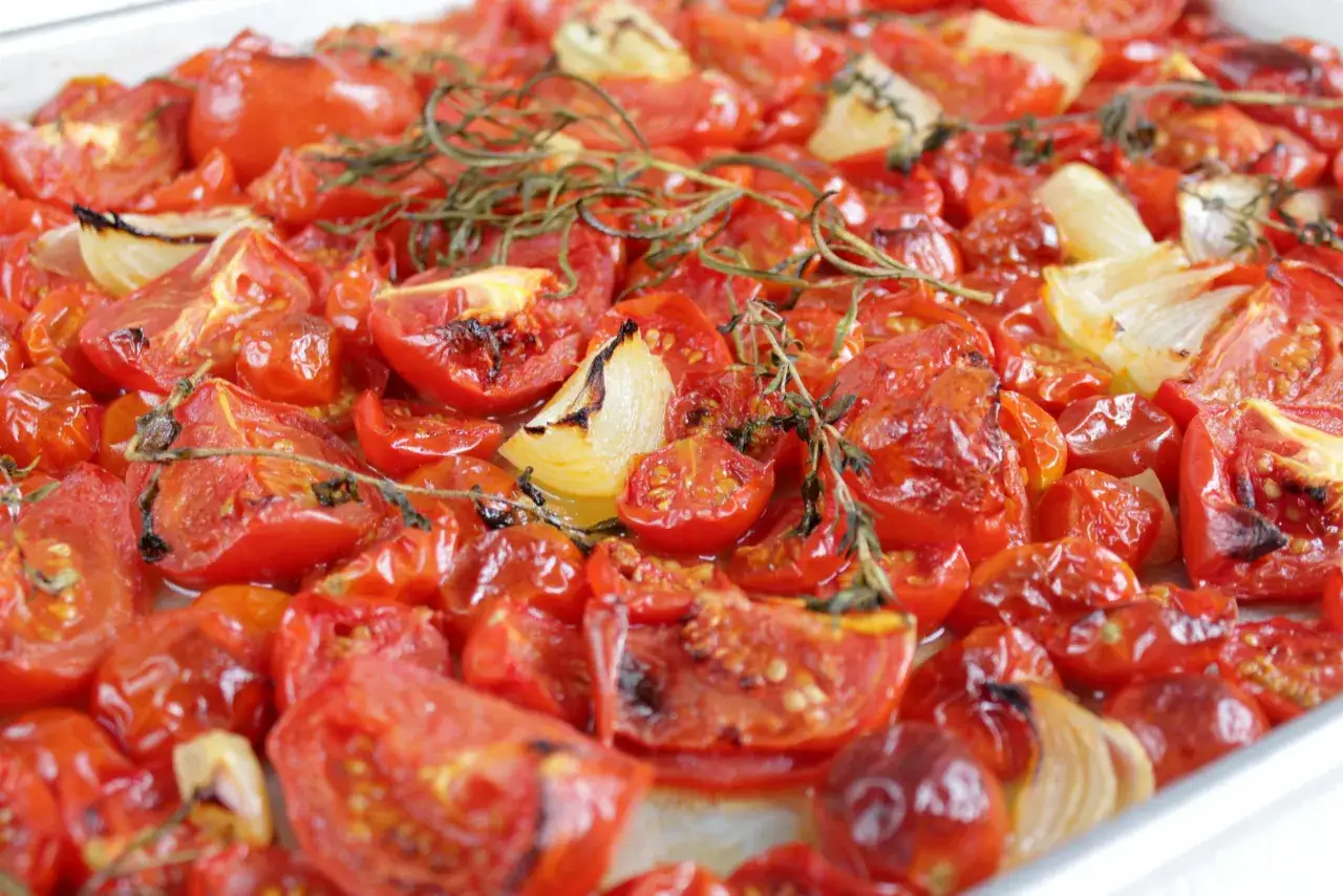 Geröstete Tomaten mit Zwiebeln und Kräutern, bereit für die Zubereitung von Nudeln mit Tomatensauce.
