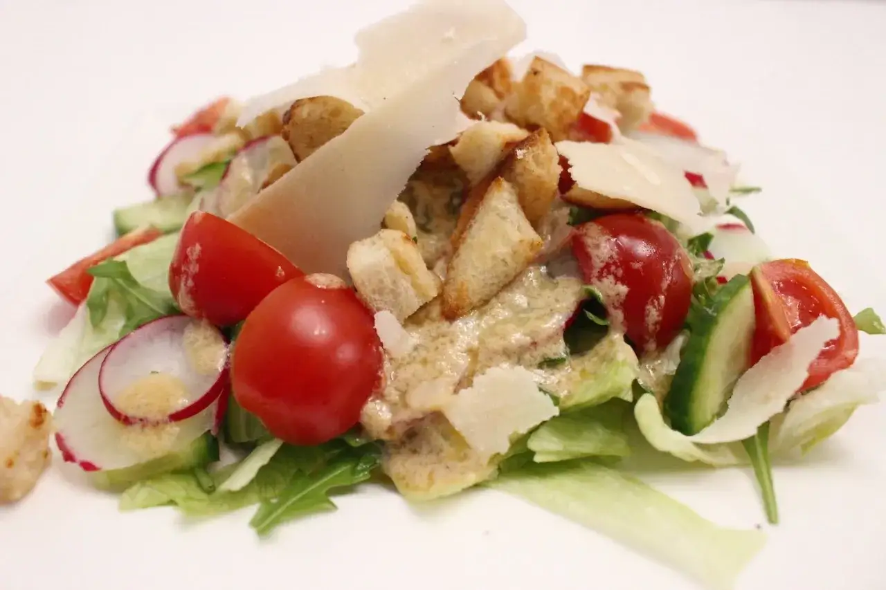 Frischer Caesar Salad mit knackigem Salat, Kirschtomaten, Gurken, Radieschen, Croutons und Parmesan.