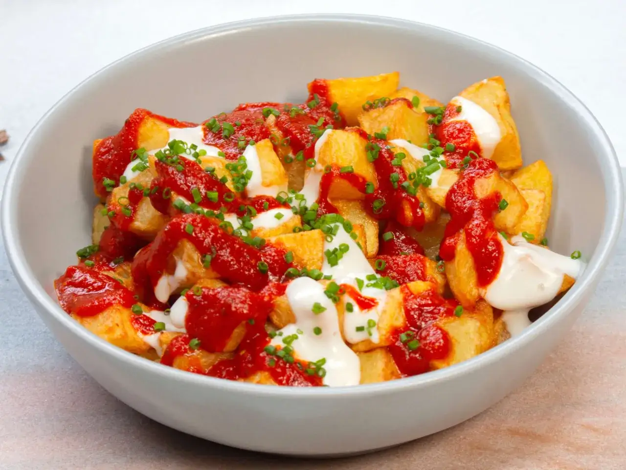 Knusprige Kartoffelw&uuml;rfel mit w&uuml;rziger Salsa Brava und cremiger Aioli, garniert mit Schnittlauch. Ein einfaches, aber k&ouml;stliches Rezept f&uuml;r Tapas.