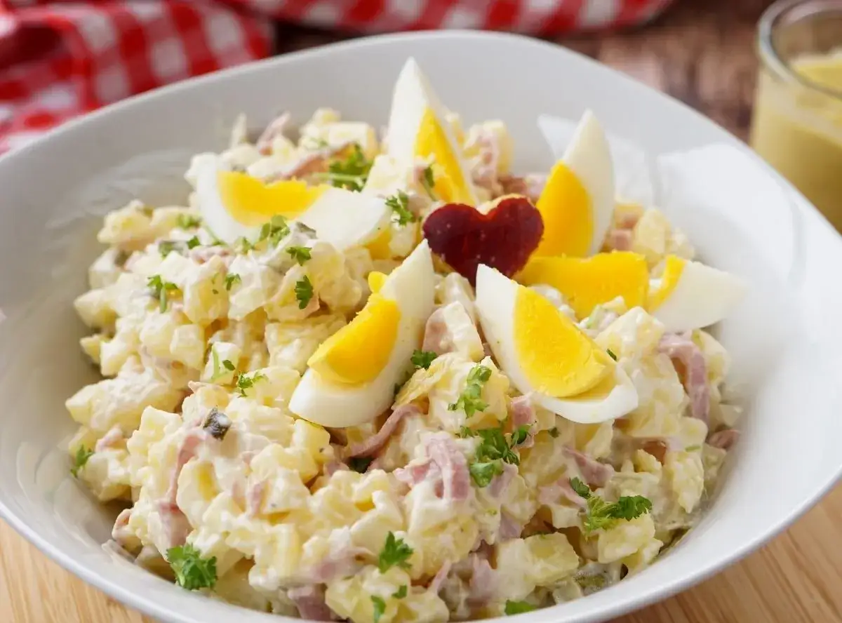 Herzhafter Kartoffelsalat mit Fleischsalat, garniert mit Ei und Petersilie. Ein Klassiker, der immer schmeckt!