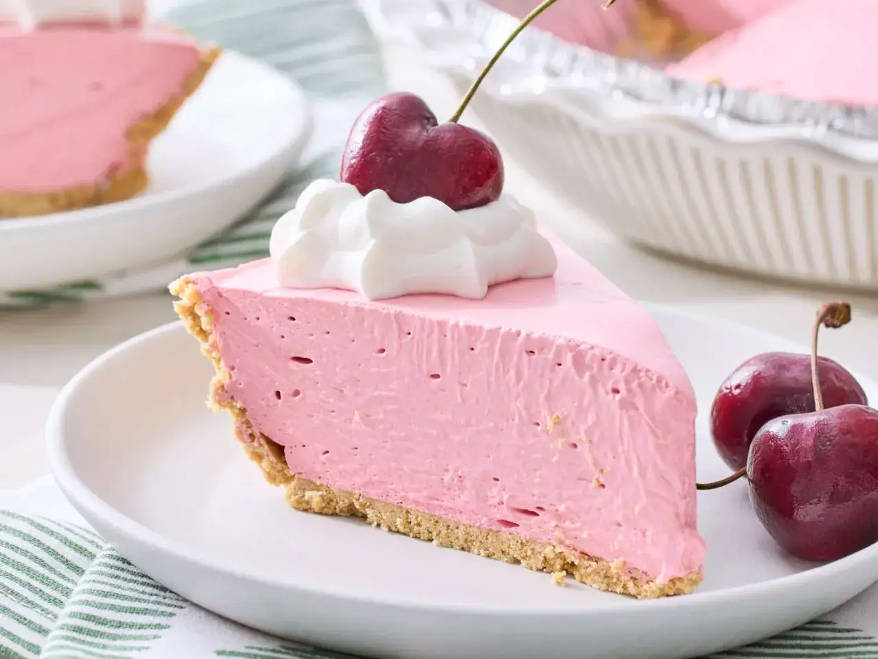 Ein St&uuml;ck cremiger Kirschkuchen mit Sahne und Kirschen. Perfekt f&uuml;r einfache Desserts ohne Backen.