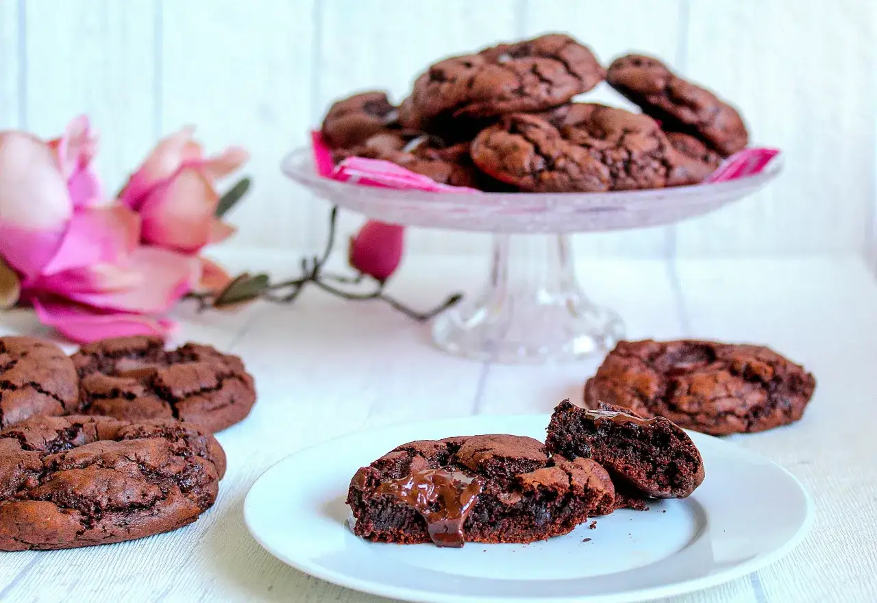 Saftige Schoko-Cookies, perfekt für ein soft cookies rezept. Ein Cookie ist aufgeschnitten und zeigt den geschmolzenen Kern.