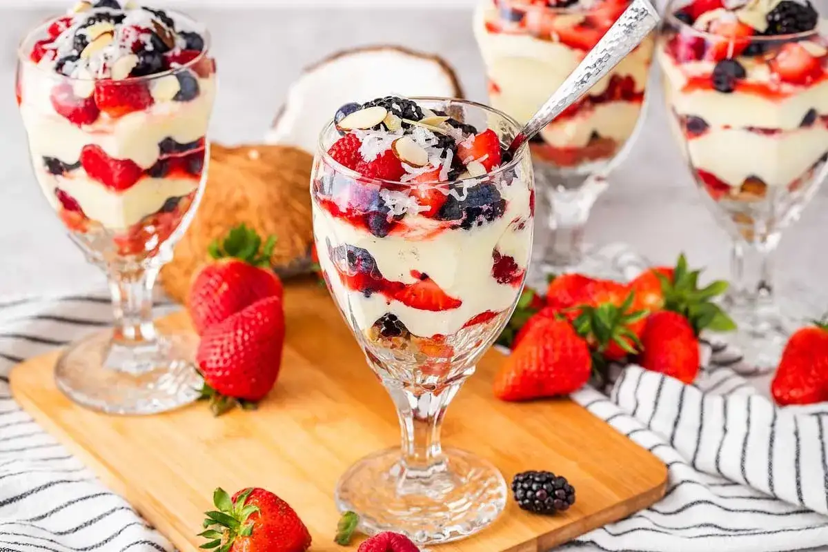 Schicht für Schicht ein Genuss: Fruchtiger nachtisch im glas mit Beeren, Sahne und Mandelsplittern.