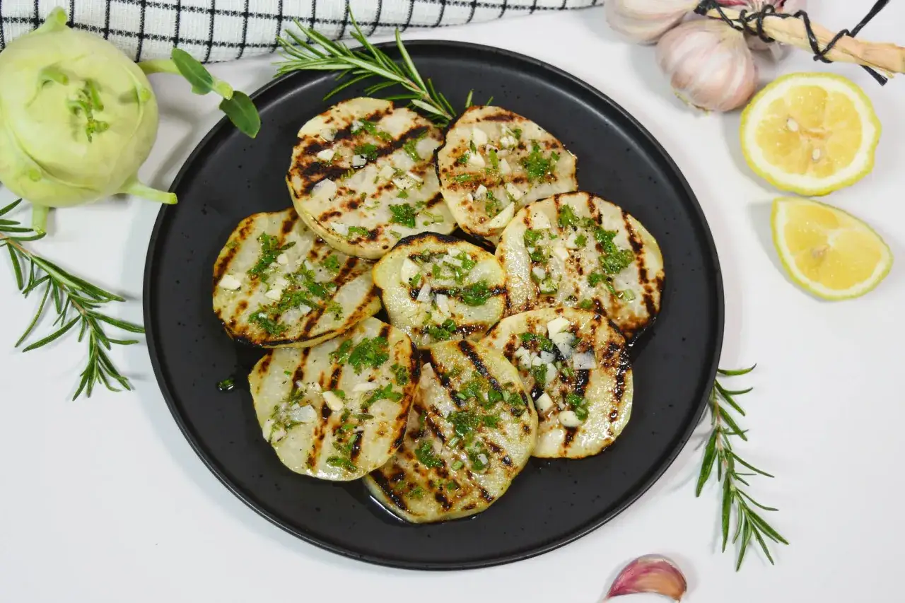 Gegrillte Kohlrabischeiben mit Kräutern und Knoblauch. Man kann Kohlrabi grillen und es schmeckt köstlich! Dazu Zitrone und Rosmarin.