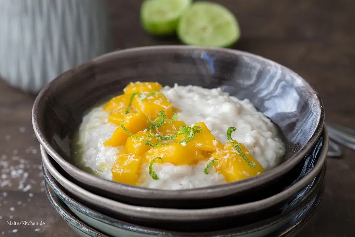 Cremiger Milchreis mit süßen Mangostücken und Kokosraspeln, eine köstliche Variante von Mango Sticky Rice.