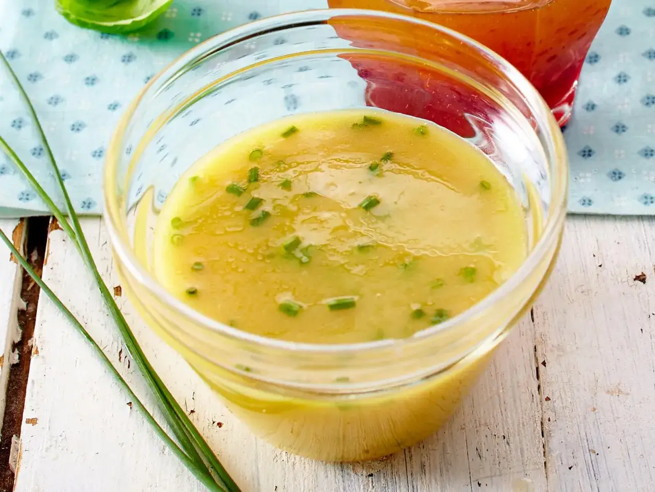 Ein Glas mit Honig-Senf-Dressing, garniert mit Schnittlauch. Perfekt für ein leichtes Salat-Rezept.