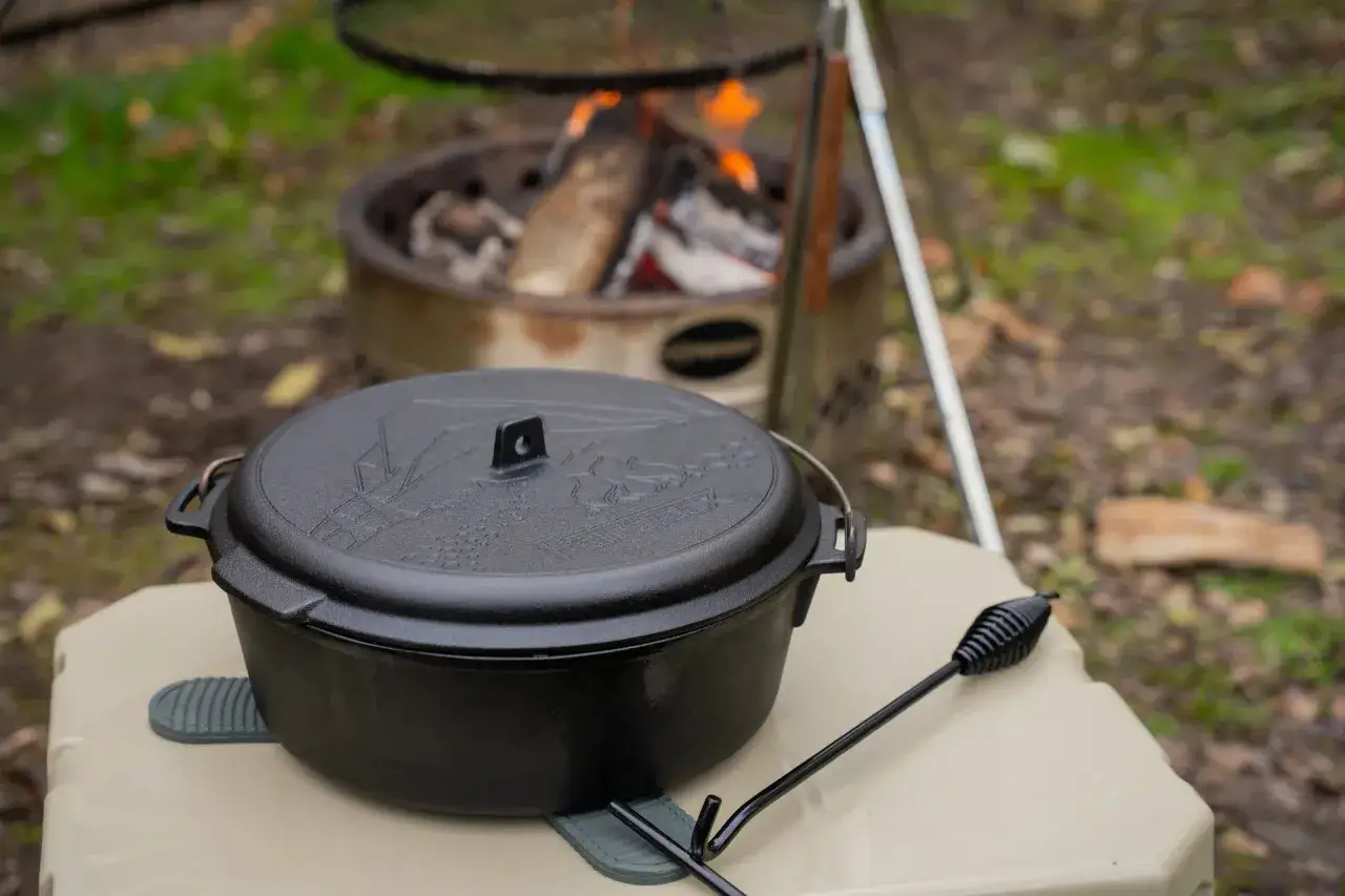 Schwarzer Dutch Oven auf einem Tisch, bereit für köstliche Dutch Oven Rezepte am Lagerfeuer.