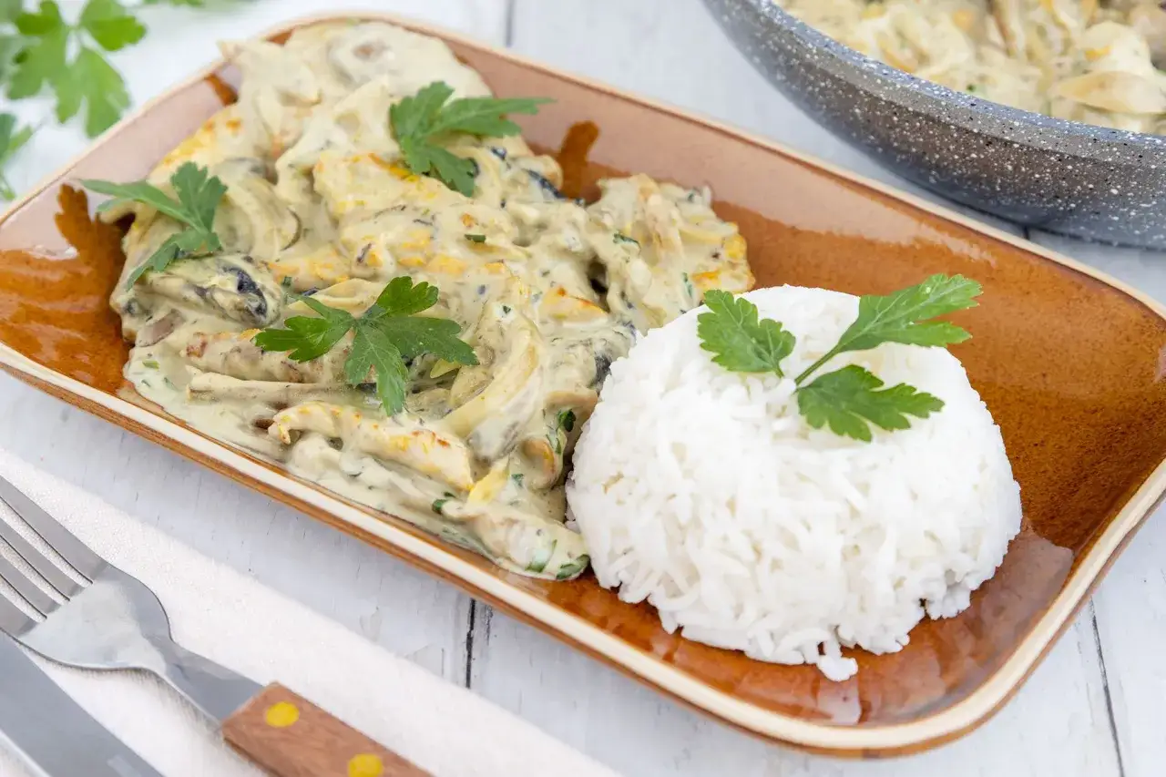 Putengeschnetzeltes im Airfryer mit cremiger Sauce und Reis, garniert mit Petersilie. Ein köstliches Gericht, das schnell zubereitet ist.
