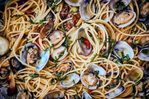 Spaghetti mit Muscheln, ein köstliches Gericht mit zarten Muscheln und perfekt gekochten Nudeln, garniert mit frischen Kräutern.