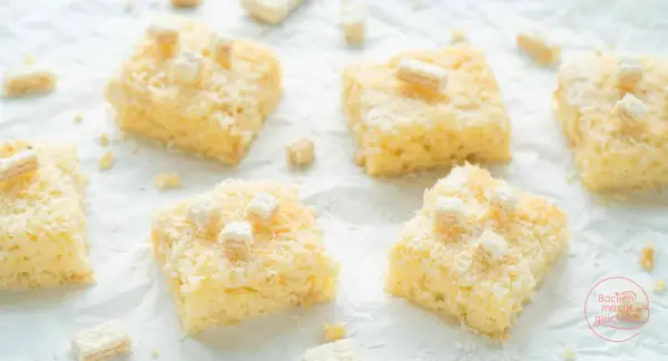 Saftiger kokos buttermilch kuchen, bestreut mit Kokosraspeln und kleinen Keksstückchen. Ein Genuss für jeden Kaffeetisch!